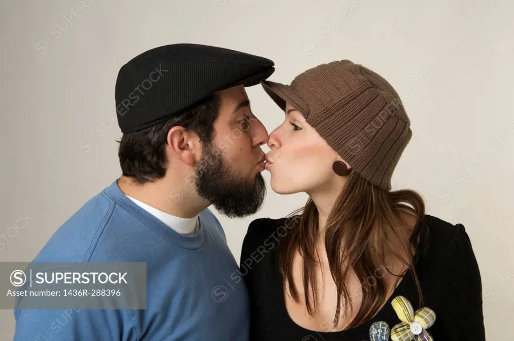 Young trendy couple holding kissing in a studio setting