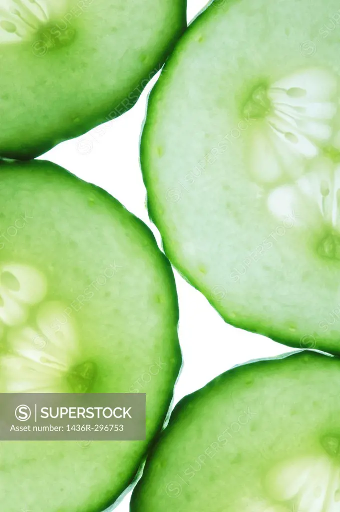 Close up of slices of lush green cucumber lit from underneath