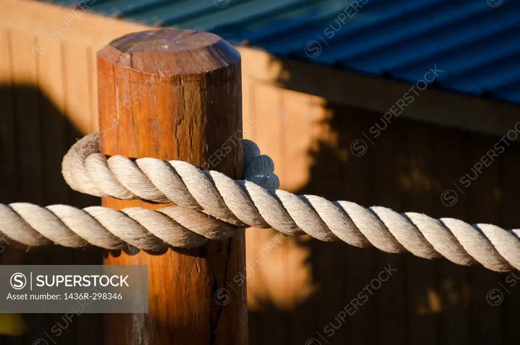 Close-up of heavyweight nautical rope secured to a dock