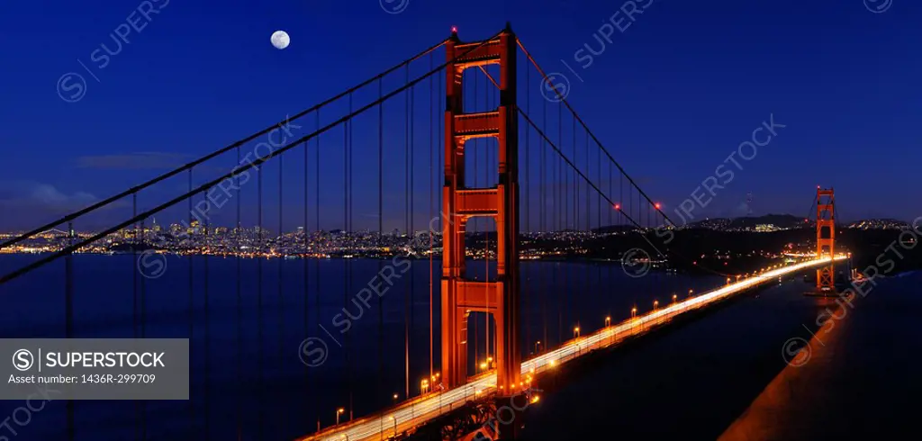Panorama of Golden Gate Bridge and San Francisco skyline at night with rising moon