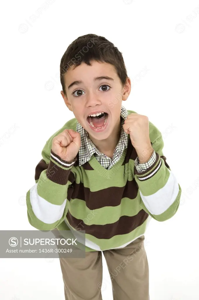 Young angry caucasian boy dressed in a casual outfit and standing on a white background