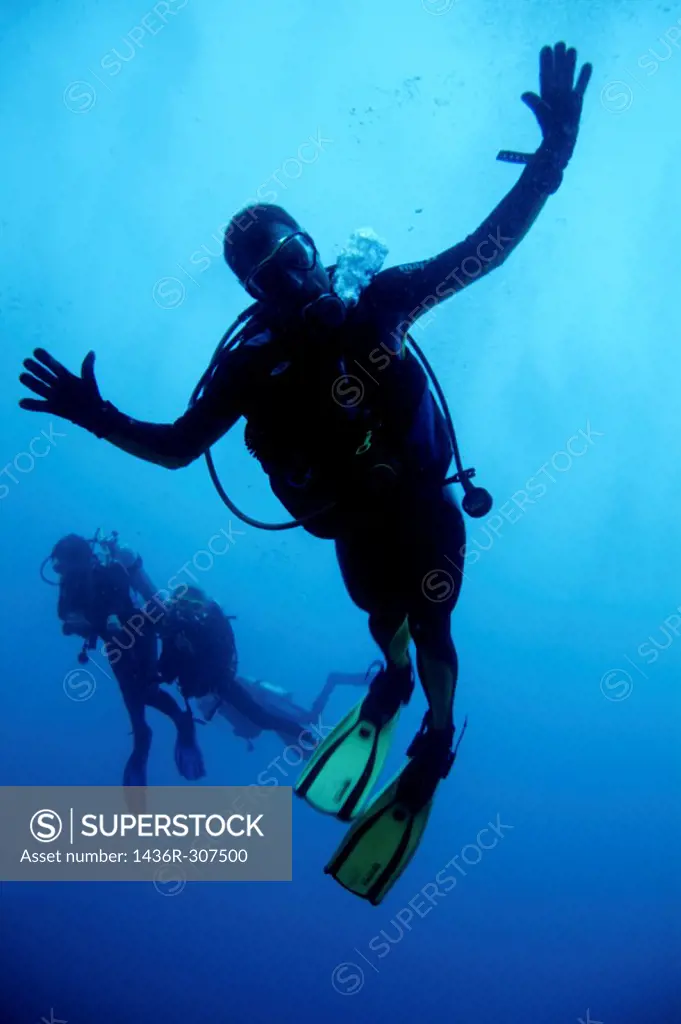 Scuba divers making faces for the camera, Ross Atoll, Maldive Islands.