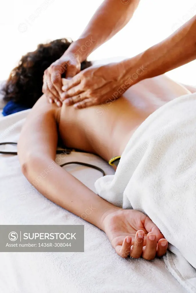 A man practicing a deep tissue massage on a womans back