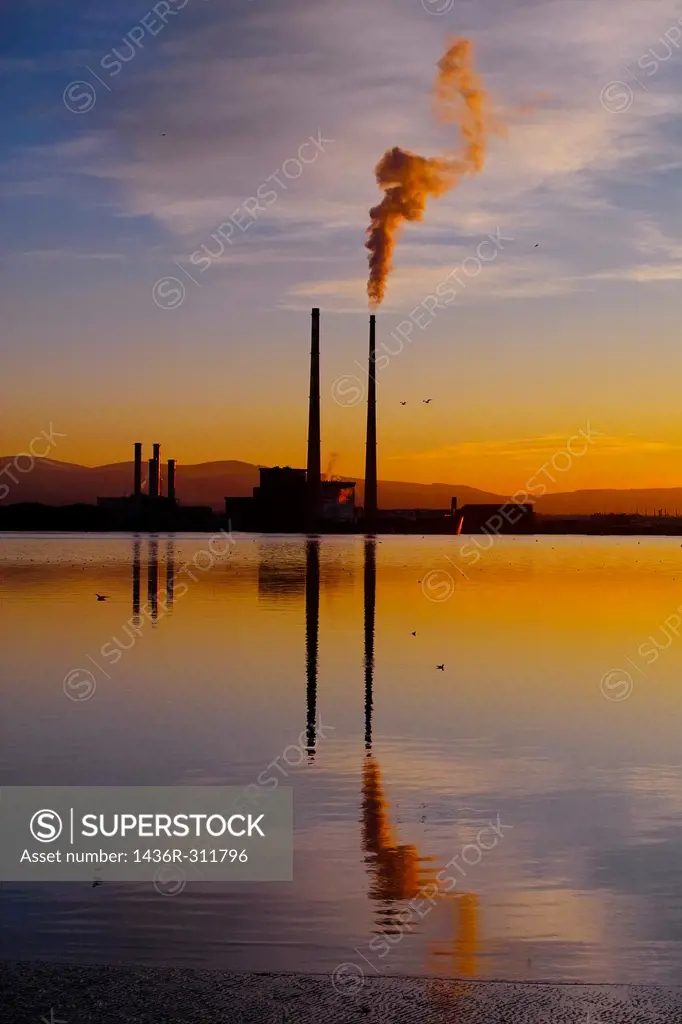 Sunset over Dublin Bay, Ireland  In the centre is Poolbeg Power Station, with smoke billowing from its right cooling tower