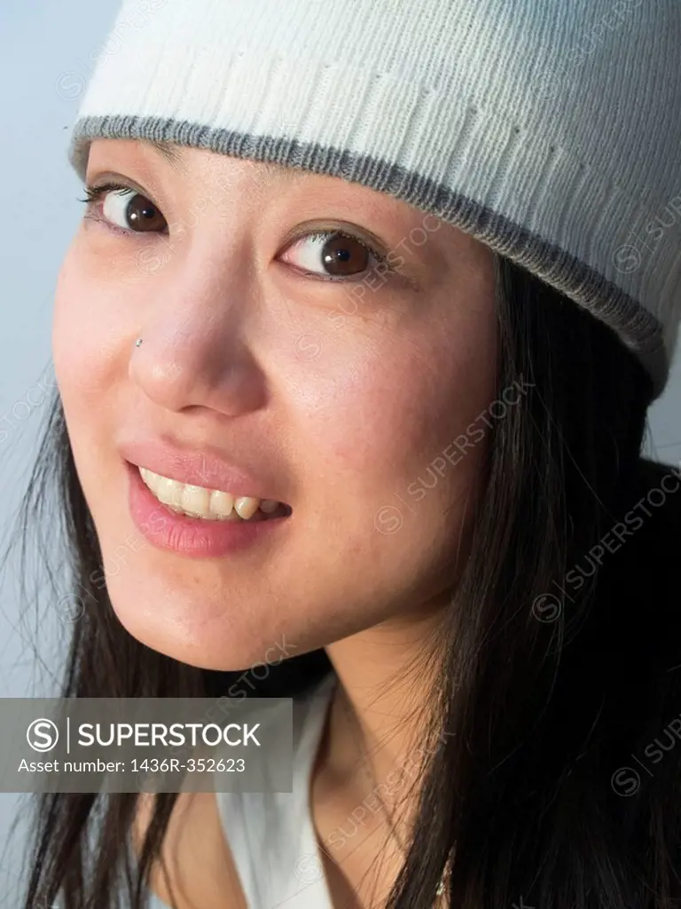 young good looking asian girl wearing a winter hat.