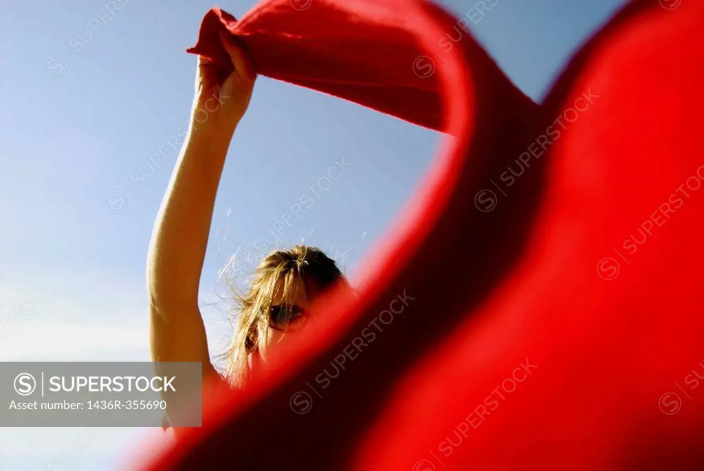 20 years old girl on beach wind blowing red towel. Kitsalano Beach. Vancouver. BC. Canada.