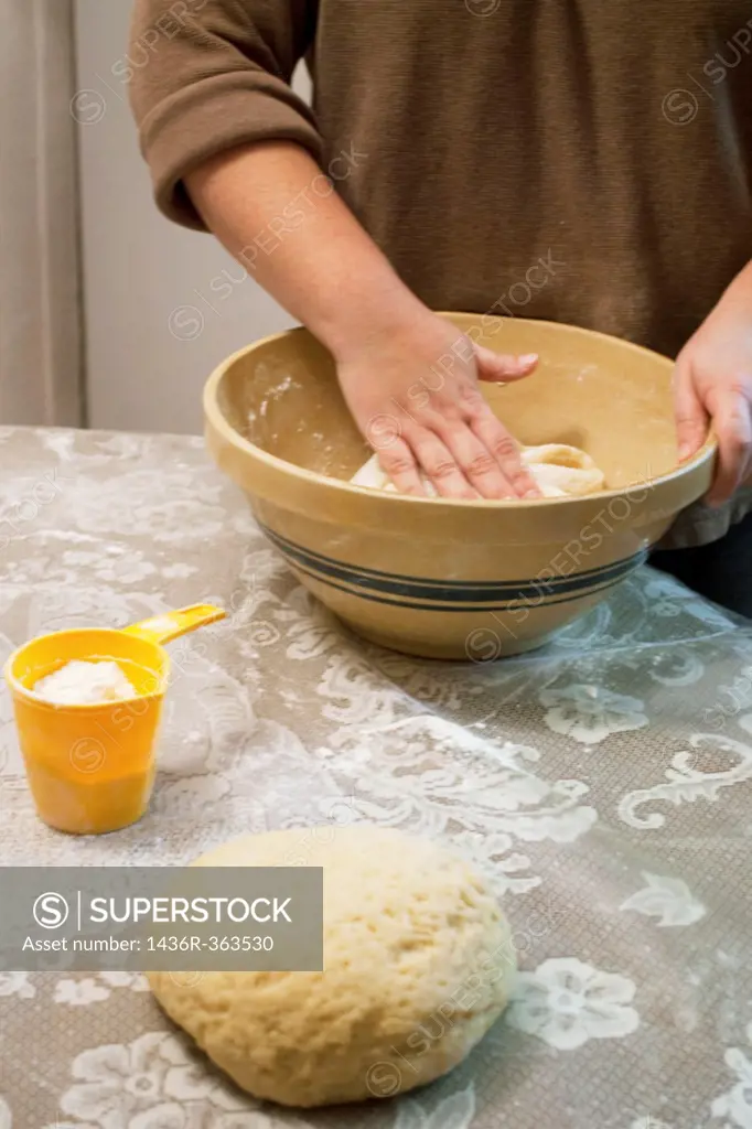 A woman´s hand folding cookie dough in a bowl
