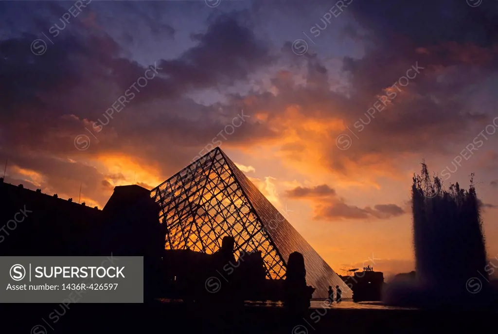 Silhouetted glass pyramid and buildings of the Musée du Louvre, Paris, France