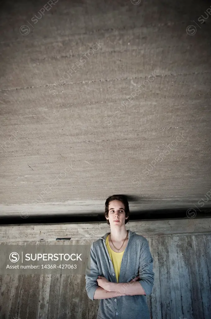 Moody young man in front of concrete wall