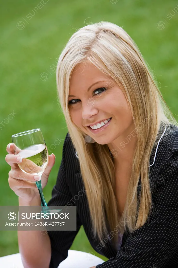 Young woman relaxing with a glass of wine in an outdoor cafe