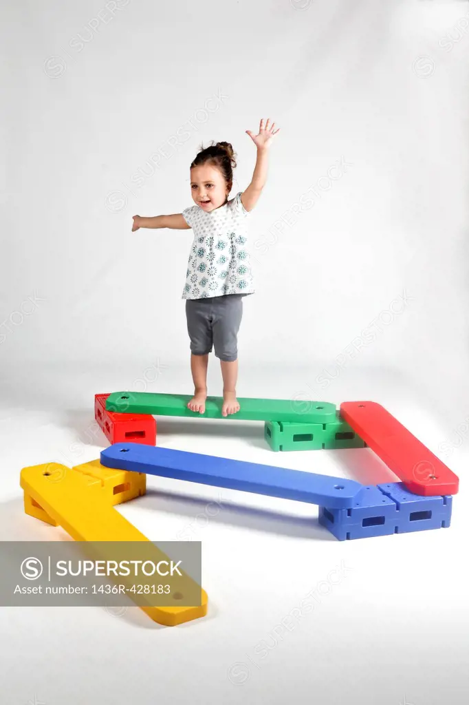 Indoor playground young girl of 4 balances On white Background MR available