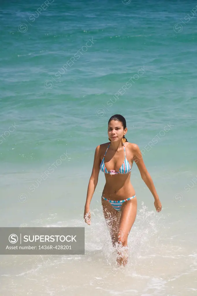 Beautiful young Brazilian woman walking in the surf of Copacabana Beach in Rio de Janeiro in Brazil
