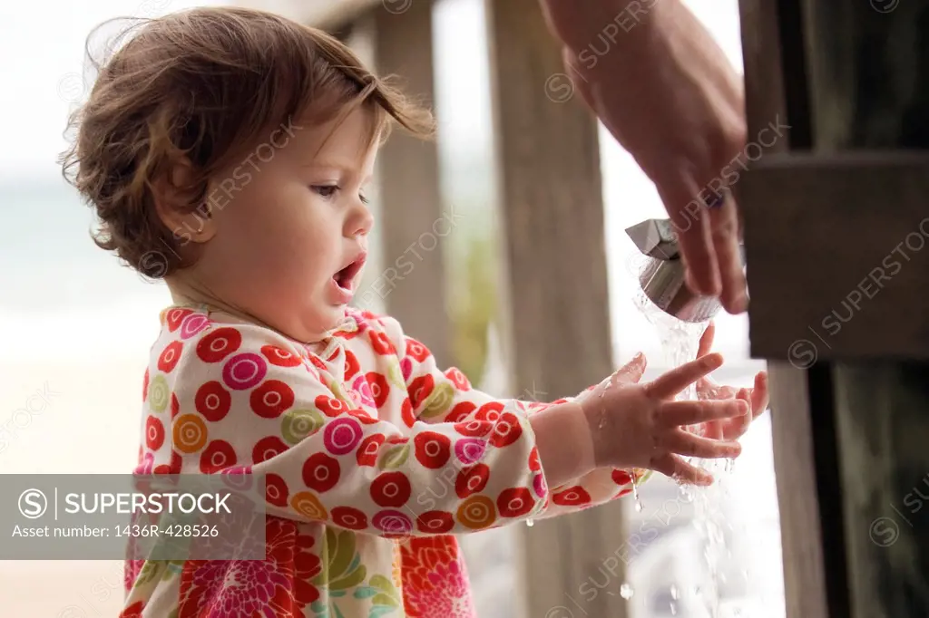 Young child washing hands at faucet near beach - Fort Lauderdale, Florida