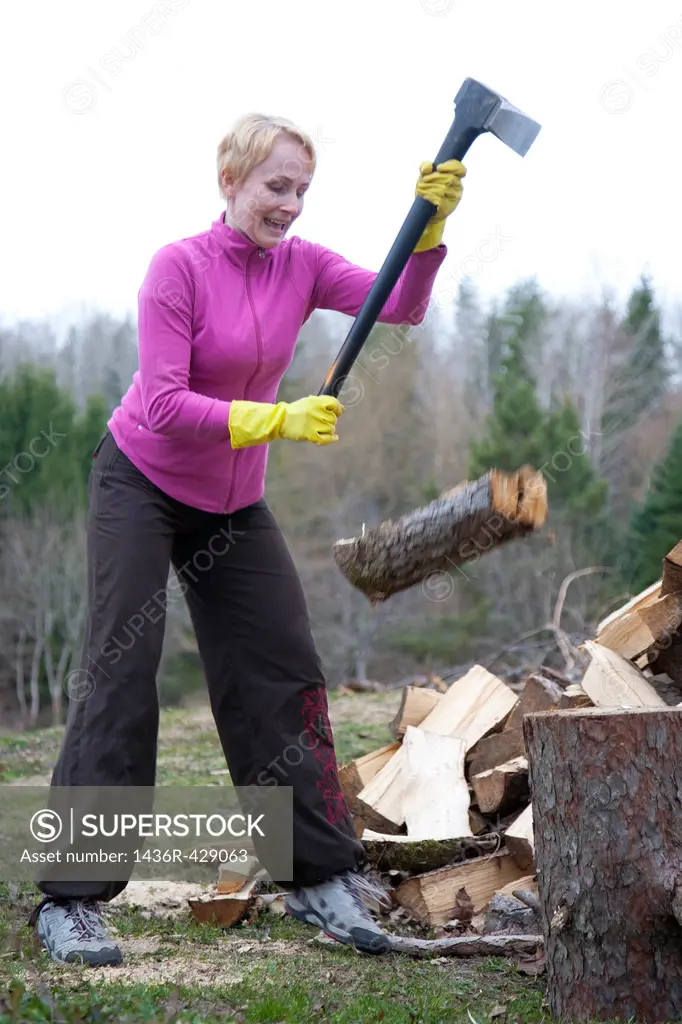 Caucasian Woman Slipping and Chopping Firewood Using Axe