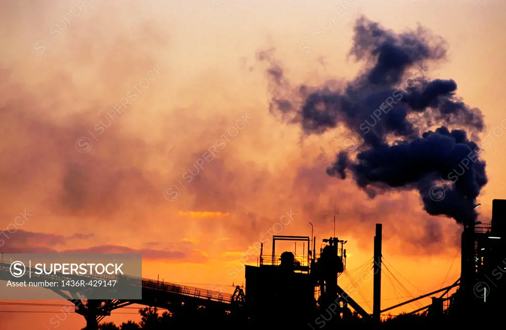 Smoking chimneys of a petroleum refinery at sunset, Berre, France
