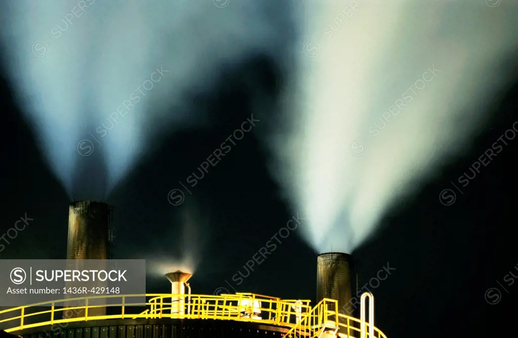 Petroleum refinery chimneys at night, France