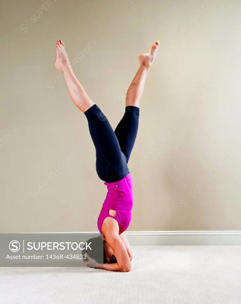 37 year old brunette woman doing a yoga pose in a home interior setting