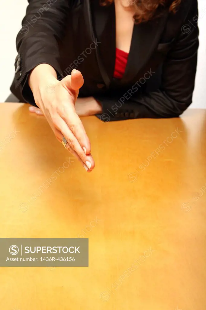 View of a business-woman sitting at a desk greeting you