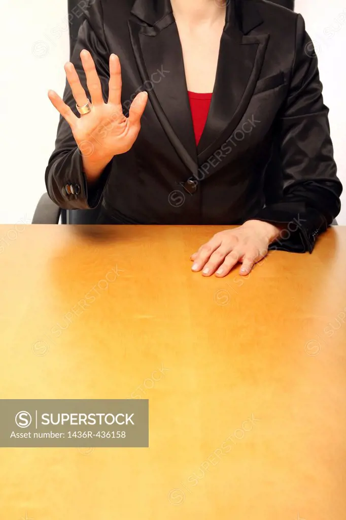 View of a business-woman sitting at a desk and counting with her fingers