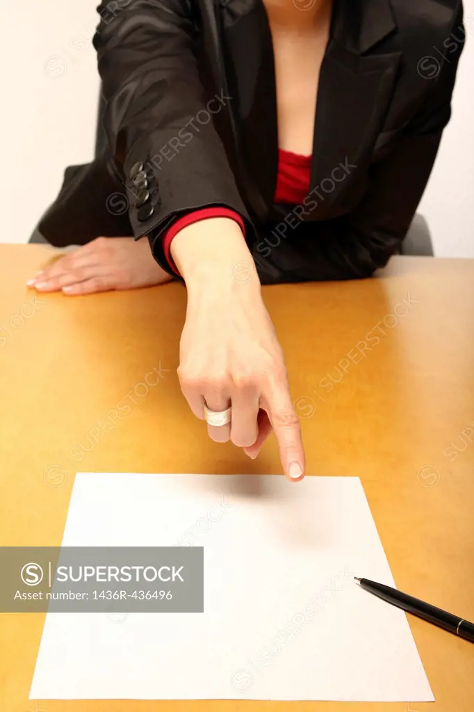 View of a business-woman sitting at the desk infront of blank paper and gesturing