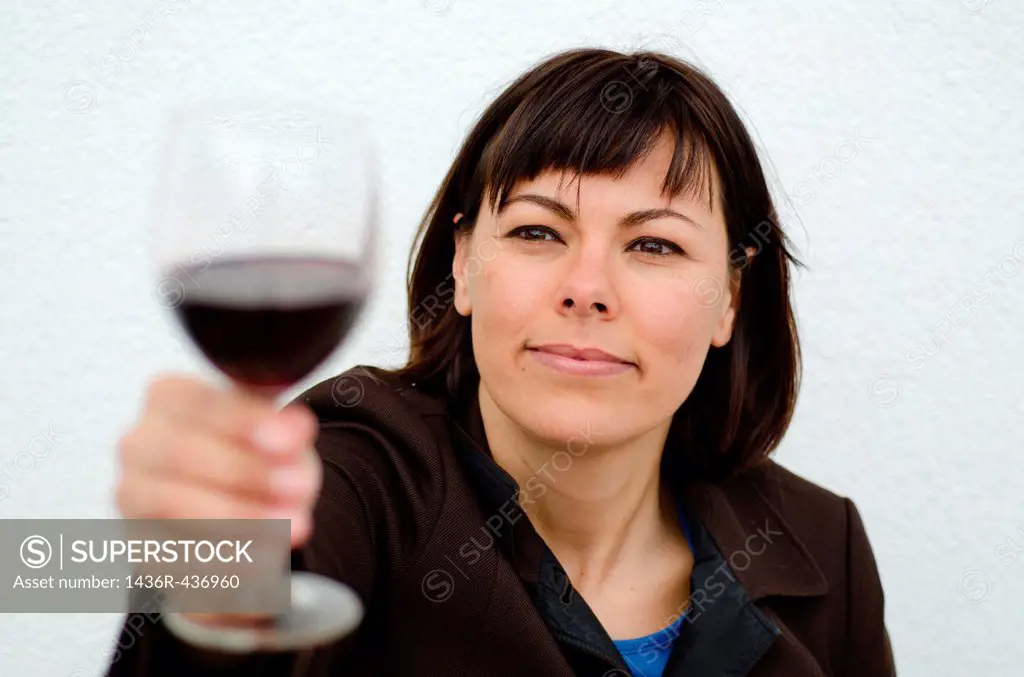 Woman holding up a glass of red wine