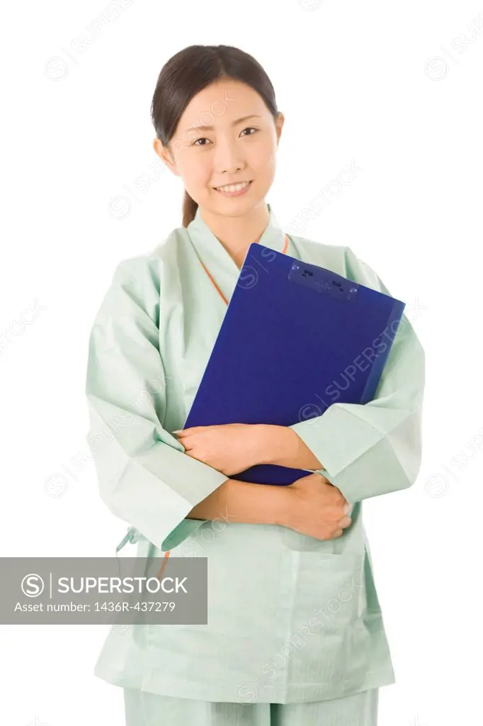 Young woman in examination gown holding clip board