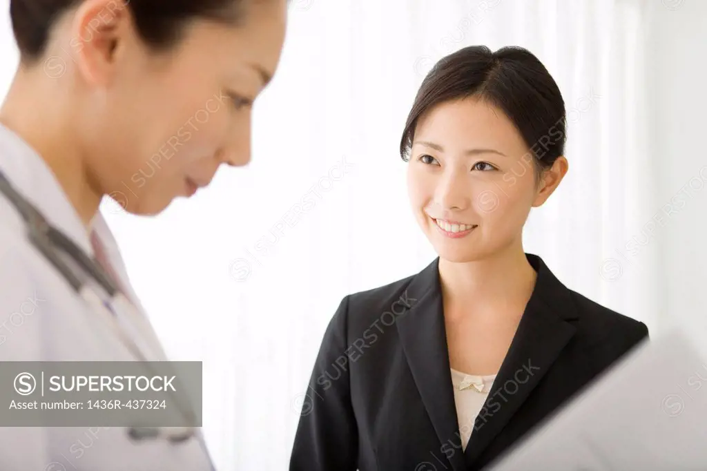 Pharmaceutical sales representative talking to female doctor