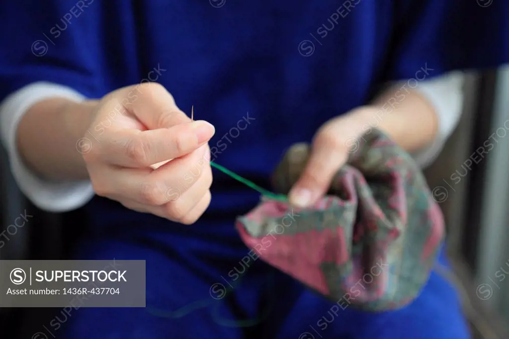 Dressmaker Sewing Cloth with Needle and Thread