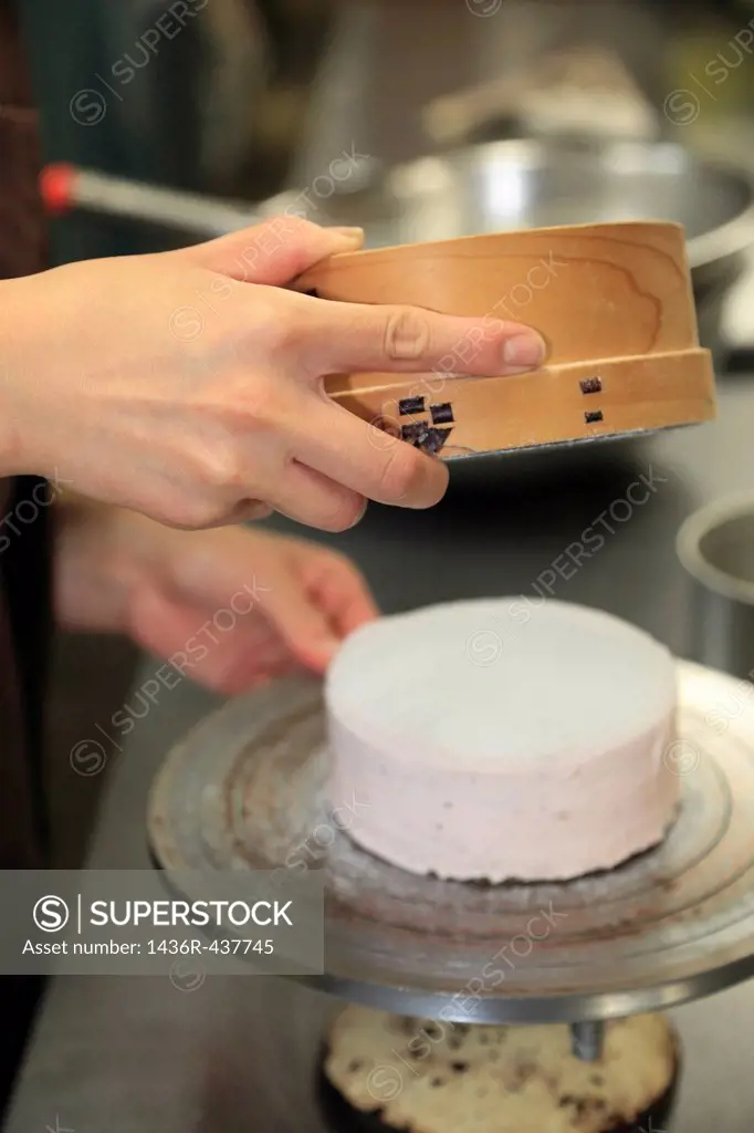 Pastry Chef Sieving Powdered Sugar on Cake