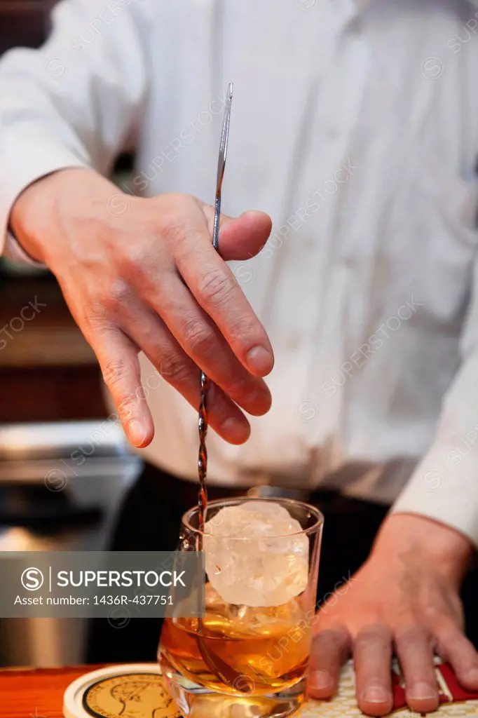 Bartender Stirring Whisky in Glass