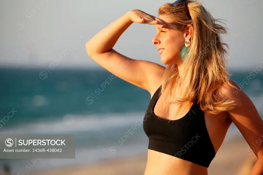 Young woman of 25 on the beach looking out to sea