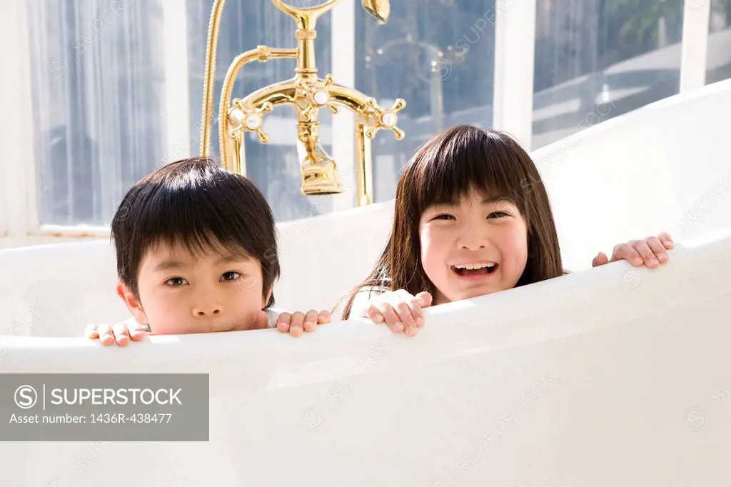 Two children playing in bathtub