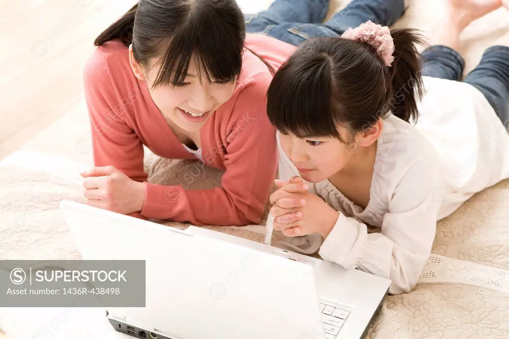 Mother and daughter looking at laptop together