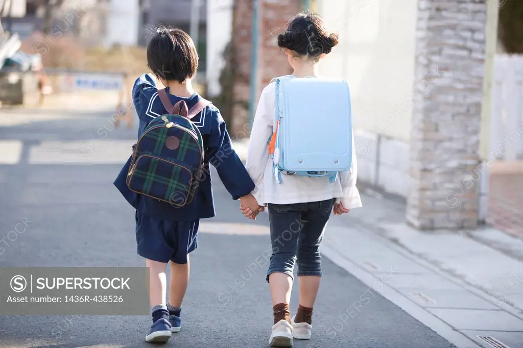 Two kids walking on road