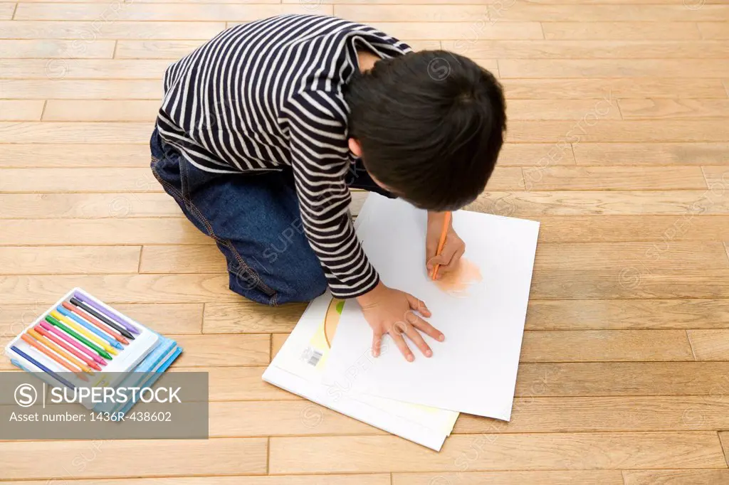 Boy kneeling and drawing picture