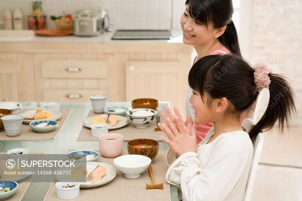 Mother and daughter sitting at dining table
