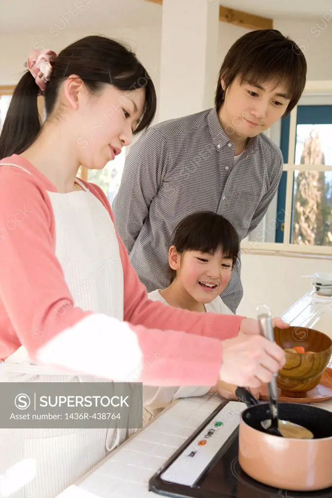 Parents and daughter standing at kitchen