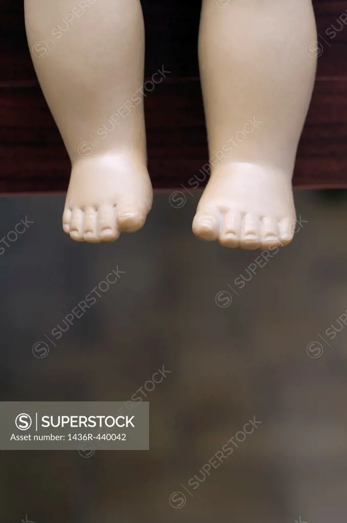 legs of toy over the edge of table