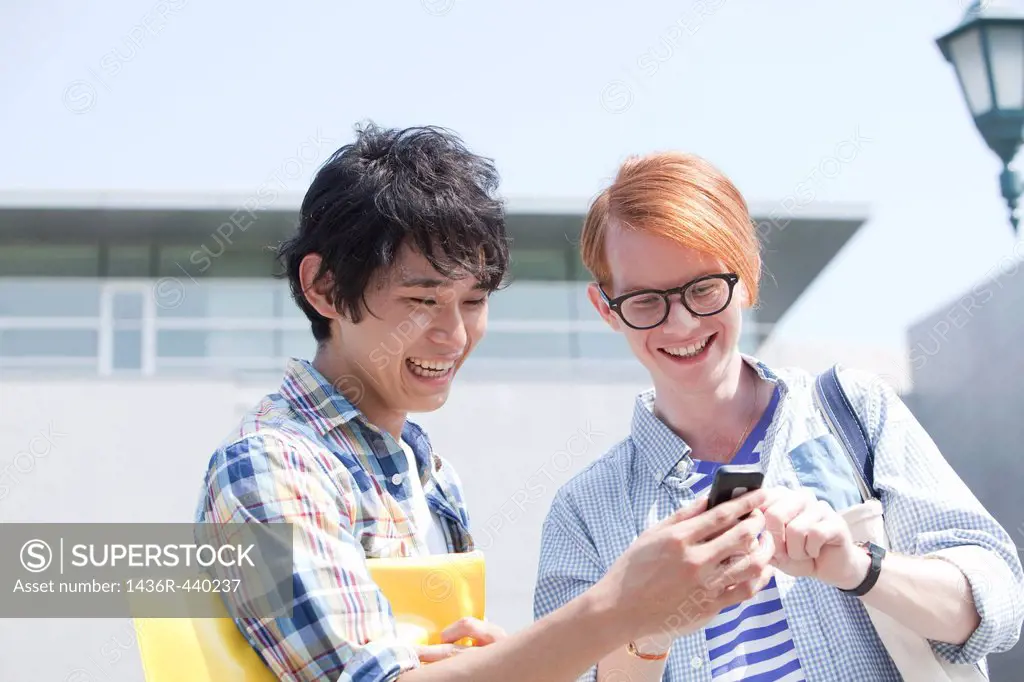 Two young men using Smartphone at campus