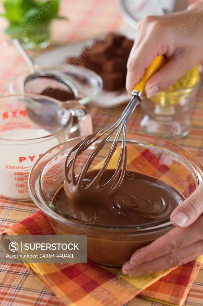 Human Hand Stirring Melted Chocolate with Whisk