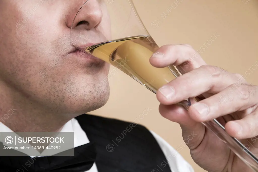 Close-up of a man drinking from a glass of champagne