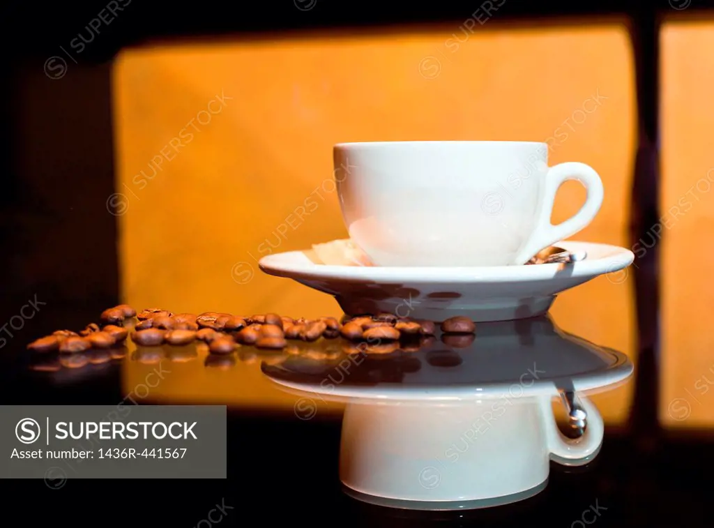 Coffee cup with coffee beans and orange background