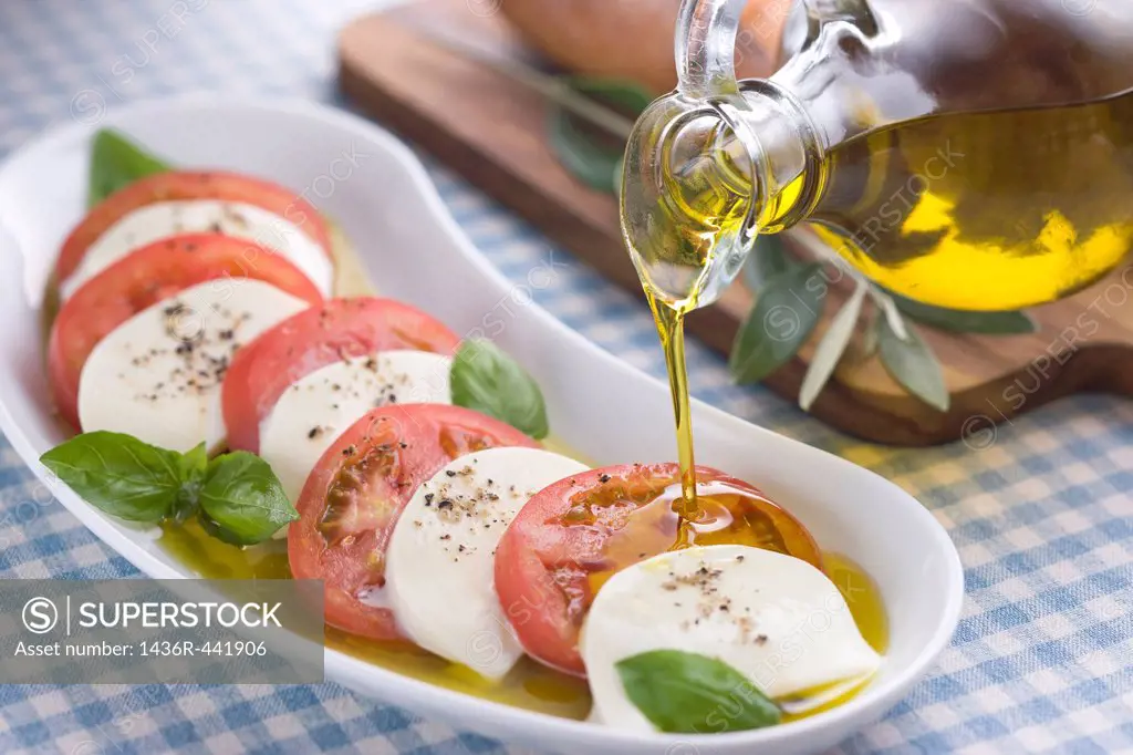 Pouring Olive Oil onto Insalata Caprese