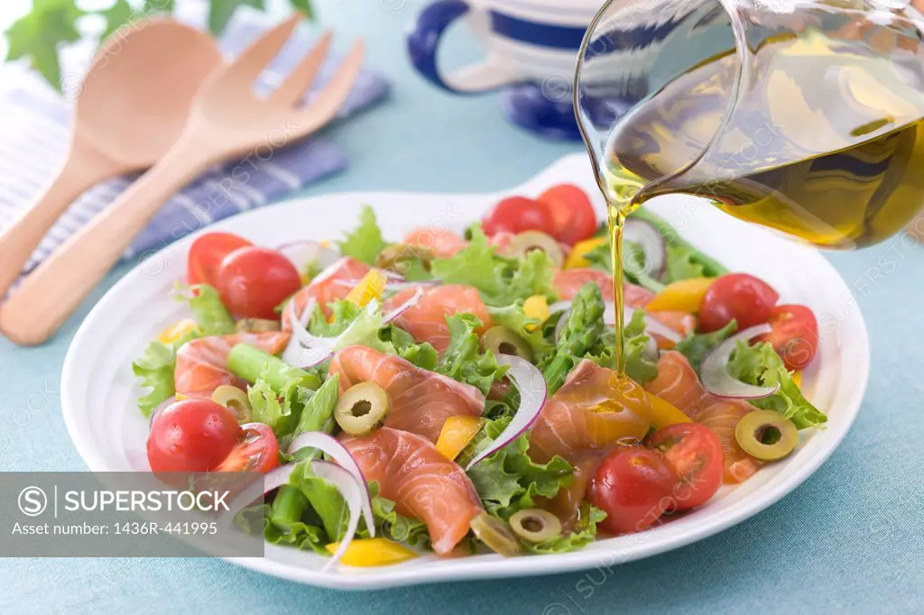 Pouring Olive Oil onto Marinated Salmon Salad