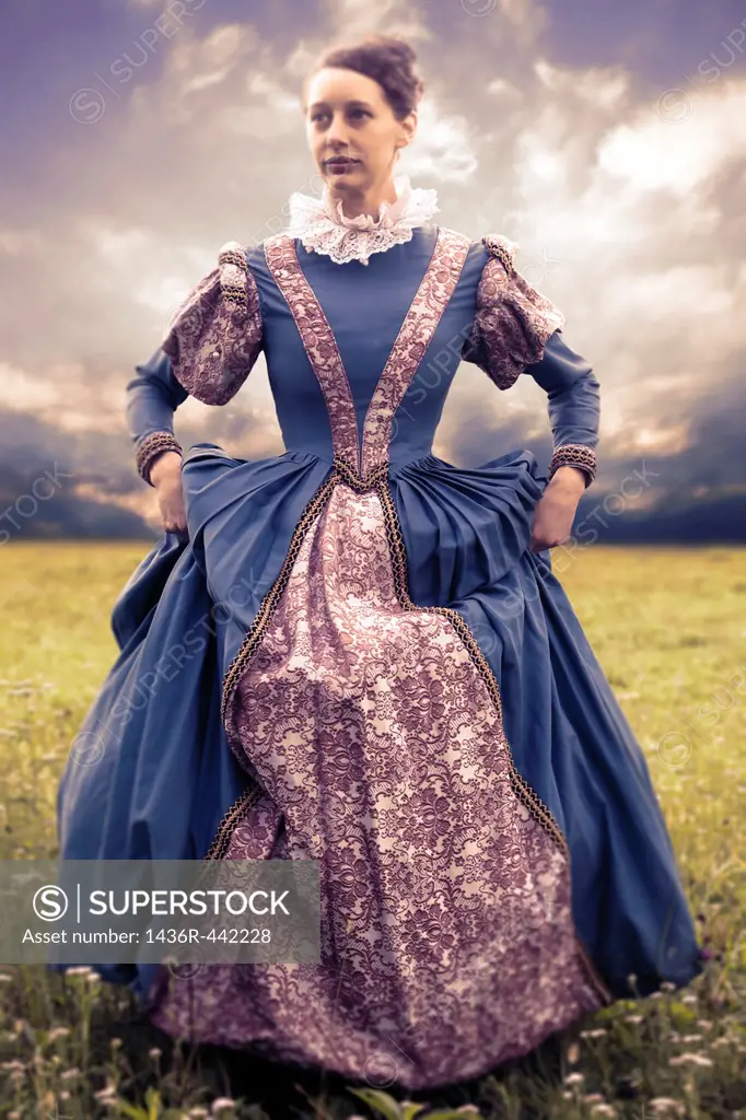 a woman in a renaissance dress in a meadow