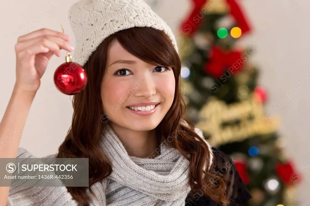 Young Woman Holding Christmas Ornament
