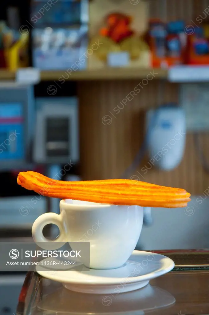 Cup of coffee with a churro on it