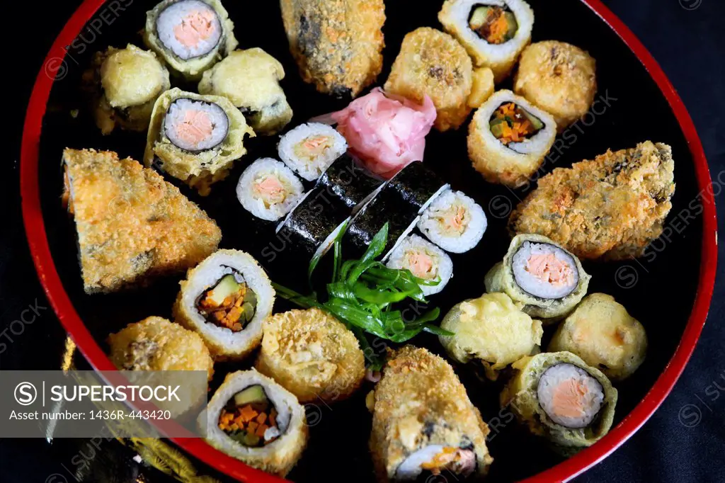 An assortment of various types of sushi including: Sushi Maki, futo maki, Insideout and deep fried sandwich
