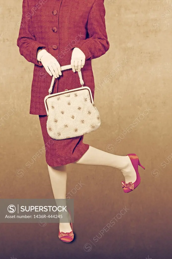 a woman in a red skirt suit with a handbag