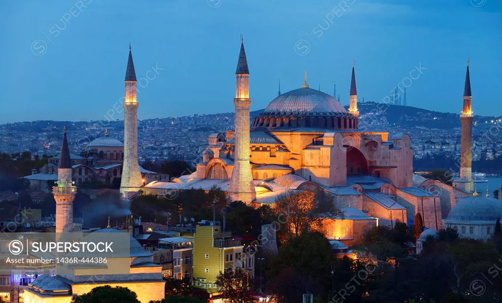 Lights on Hagia Sophia and Firuz Aga Mosque at dusk in Istanbul Turkey